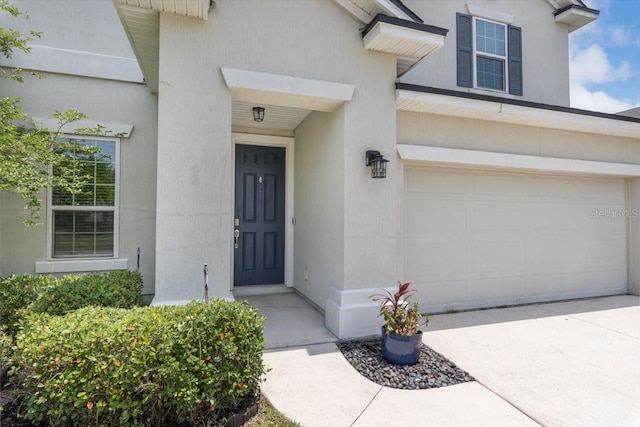 1011 Wetland Ridge Cir, Middleburg, FL 32068 - doorway to property featuring an attached garage, stucco siding, and concrete driveway