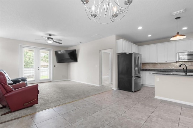 1011 Wetland Ridge Cir, Middleburg, FL 32068 - kitchen featuring stainless steel appliances, light colored carpet, open floor plan, dark countertops, and light tile patterned flooring
