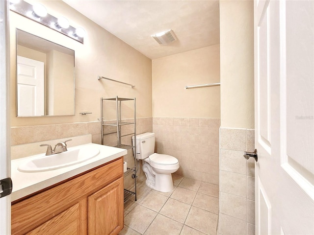 1220 SW 1st Ave Unit 304, Gainesville, FL 32601 - bathroom featuring vanity, tile walls, tile patterned flooring, and wainscoting