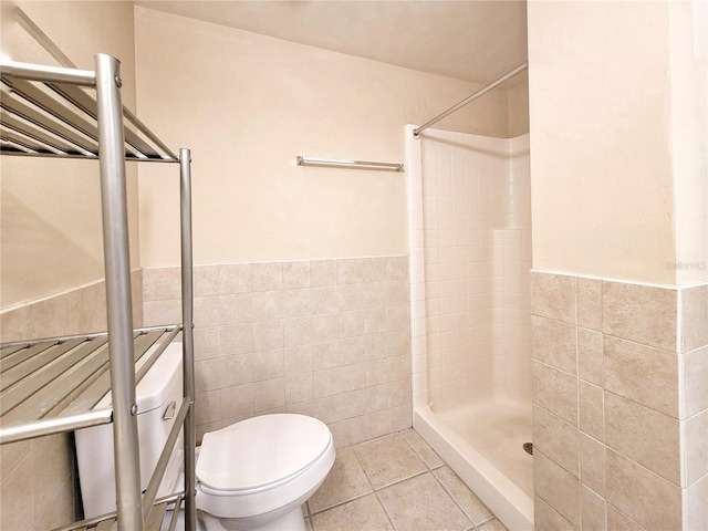 1220 SW 1st Ave Unit 304, Gainesville, FL 32601 - full bathroom featuring tile walls, a tile shower, a wainscoted wall, and tile patterned floors