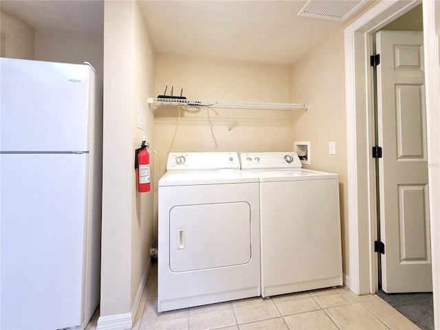 1220 SW 1st Ave Unit 304, Gainesville, FL 32601 - laundry area with light tile patterned floors and washer and dryer