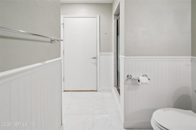 110 Cypress St, Hawthorne, FL 32640 - bathroom featuring wainscoting, an enclosed shower, marble finish floors, and a decorative wall