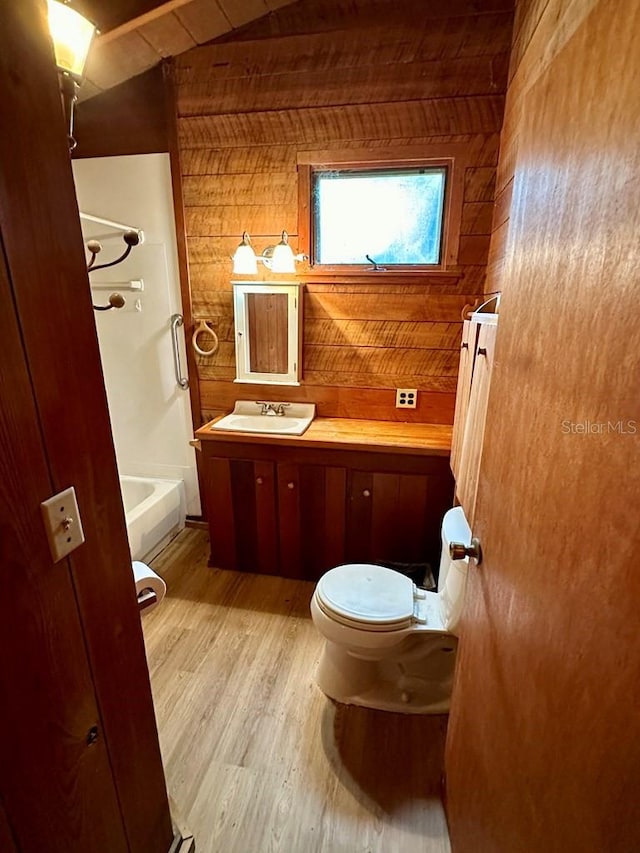 9947 SW 37th St, Lake Butler, FL 32054 - bathroom featuring wood finished floors, vanity, wooden walls, and shower / tub combination
