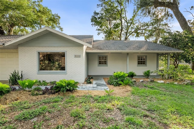 900 NW Snug Harbor Rd, Crystal River, FL 34428 - view of front facade with a garage, brick siding, and a shingled roof