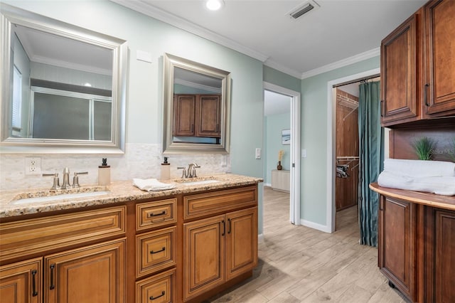 900 NW Snug Harbor Rd, Crystal River, FL 34428 - full bath with double vanity, decorative backsplash, wood finished floors, crown molding, and a shower
