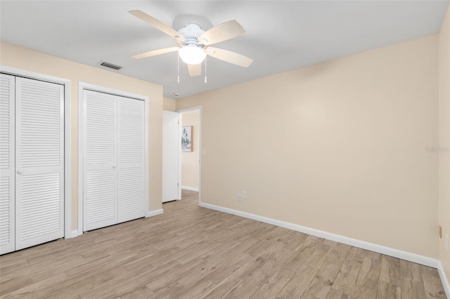 900 NW Snug Harbor Rd, Crystal River, FL 34428 - unfurnished bedroom with multiple closets, light wood finished floors, and ceiling fan