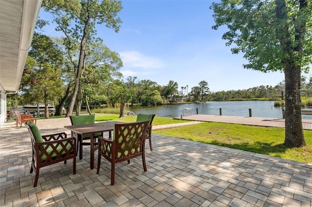900 NW Snug Harbor Rd, Crystal River, FL 34428 - view of patio featuring a water view, a dock, outdoor dining area, and view of scattered trees