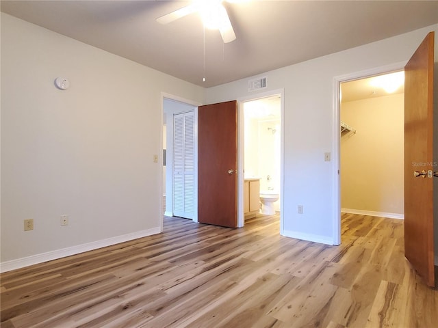 2360 SW Archer Rd Unit 208, Gainesville, FL 32608 - unfurnished bedroom with a closet, light wood-style flooring, a spacious closet, ensuite bath, and ceiling fan