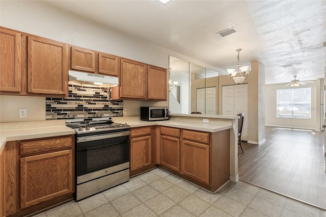 3901 SW 20th Ave Unit 806, Gainesville, FL 32607 - kitchen featuring appliances with stainless steel finishes, under cabinet range hood, a peninsula, a chandelier, and light countertops
