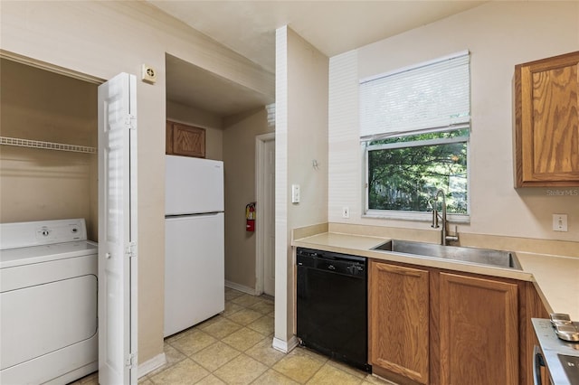 3901 SW 20th Ave Unit 806, Gainesville, FL 32607 - kitchen with black dishwasher, washer / dryer, freestanding refrigerator, light countertops, and brown cabinetry