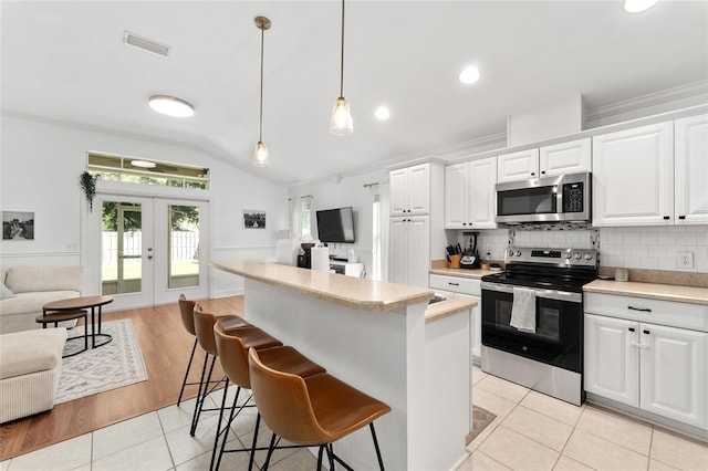 11752 NW 61st Ter, Alachua, FL 32615 - kitchen with appliances with stainless steel finishes, light countertops, lofted ceiling, a center island, and open floor plan