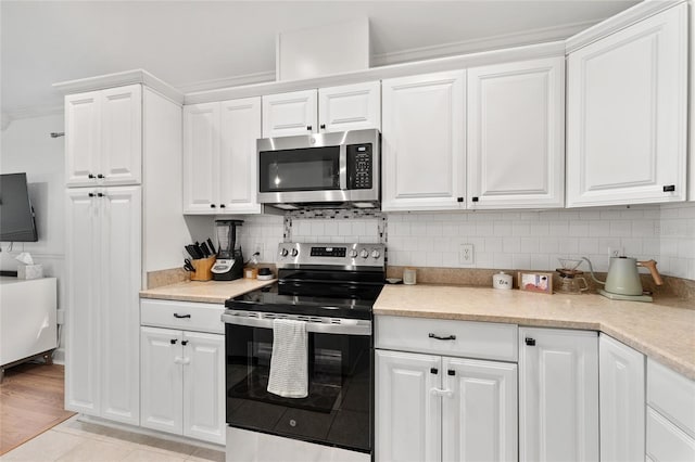 11752 NW 61st Ter, Alachua, FL 32615 - kitchen featuring stainless steel appliances, white cabinetry, tasteful backsplash, light countertops, and ornamental molding