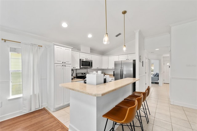 11752 NW 61st Ter, Alachua, FL 32615 - kitchen with stainless steel appliances, light tile patterned flooring, light countertops, ornamental molding, and white cabinetry
