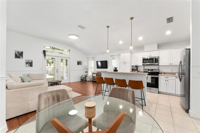 11752 NW 61st Ter, Alachua, FL 32615 - dining area with french doors, lofted ceiling, light wood-style flooring, and recessed lighting
