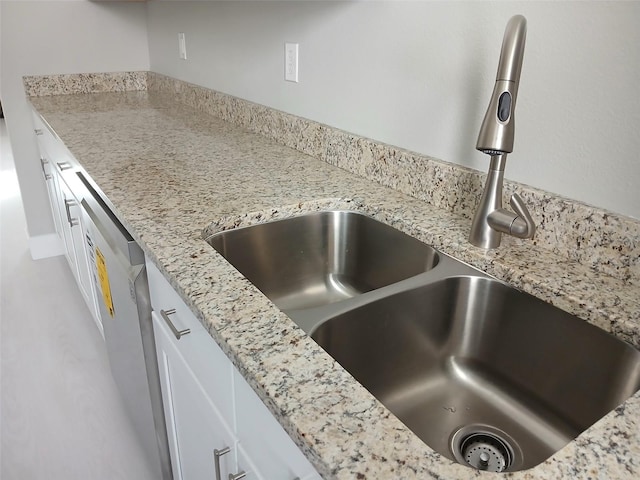 6519 W Newberry Rd Unit 404, Gainesville, FL 32605 - kitchen view of white cabinets, light stone countertops, and dishwasher