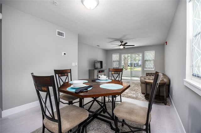 6519 W Newberry Rd Unit 404, Gainesville, FL 32605 - dining area featuring a ceiling fan, light wood-style floors, and a textured ceiling