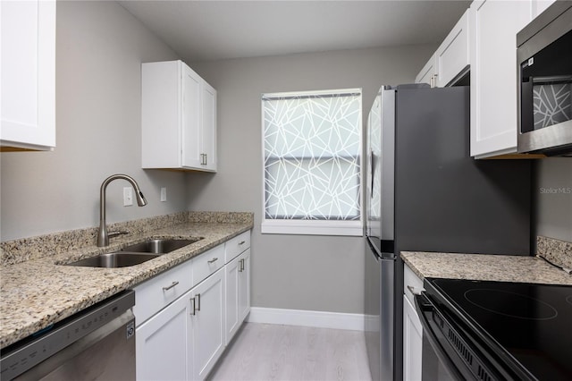 6519 W Newberry Rd Unit 404, Gainesville, FL 32605 - kitchen with stainless steel appliances, white cabinetry, light stone countertops, and light wood-style floors