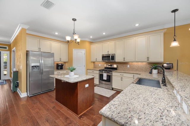 7827 SW 79th Dr, Gainesville, FL 32608 - kitchen with appliances with stainless steel finishes, cream cabinets, light stone counters, decorative backsplash, and crown molding