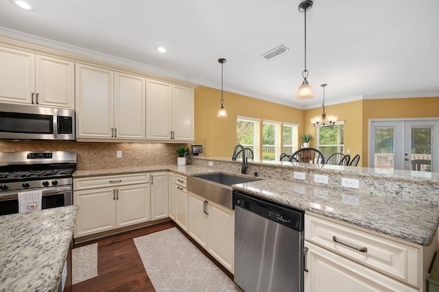 7827 SW 79th Dr, Gainesville, FL 32608 - kitchen with stainless steel appliances, ornamental molding, dark wood-style floors, pendant lighting, and backsplash