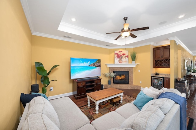 7827 SW 79th Dr, Gainesville, FL 32608 - living area with wood finished floors, a tile fireplace, ceiling fan, beverage cooler, and a tray ceiling