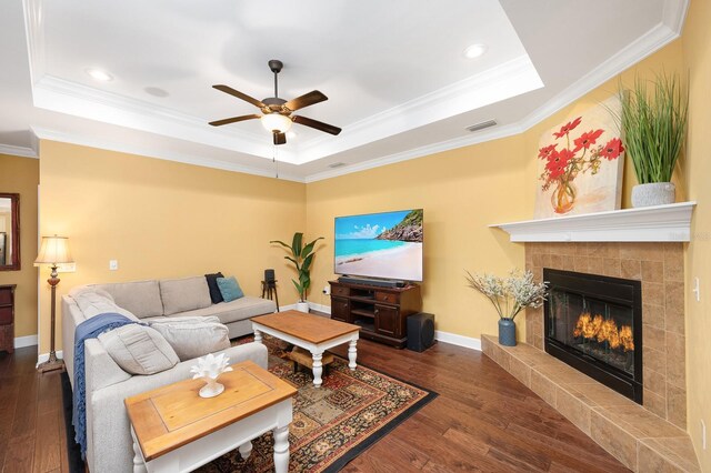 7827 SW 79th Dr, Gainesville, FL 32608 - living area featuring a tray ceiling, a ceiling fan, a tile fireplace, wood finished floors, and crown molding