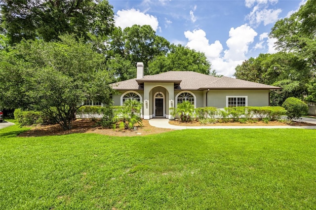 2013 SW 76th Ter, Gainesville, FL 32607 - mediterranean / spanish-style house featuring a chimney, a front lawn, and stucco siding