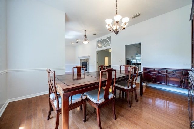2013 SW 76th Ter, Gainesville, FL 32607 - dining room with a chandelier, light wood-style floors, and a fireplace