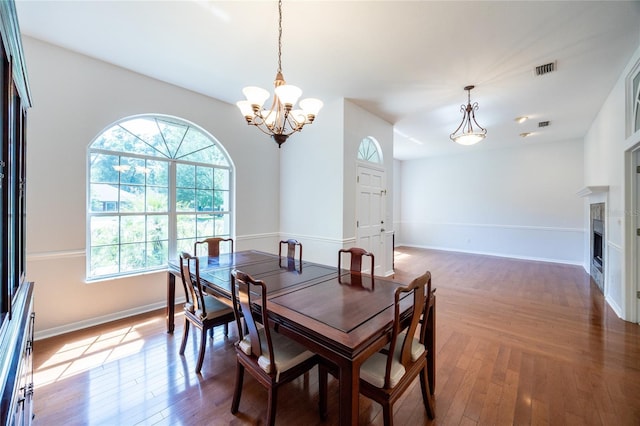 2013 SW 76th Ter, Gainesville, FL 32607 - dining room featuring a chandelier, wood finished floors, and a fireplace