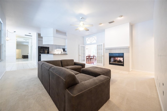 2013 SW 76th Ter, Gainesville, FL 32607 - living room featuring light carpet, a ceiling fan, and a tile fireplace