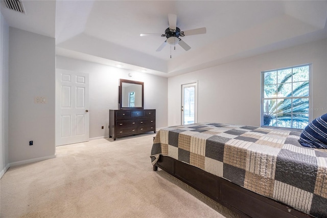 2013 SW 76th Ter, Gainesville, FL 32607 - bedroom featuring a tray ceiling, light colored carpet, multiple windows, and a ceiling fan