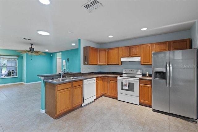 350 Hardee St, Bronson, FL 32621 - kitchen featuring white appliances, brown cabinets, a peninsula, dark countertops, and recessed lighting