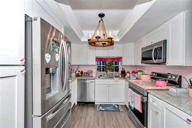 487 Midway Dr Unit B, Ocala, FL 34472 - kitchen featuring stainless steel appliances, a tray ceiling, a chandelier, white cabinetry, and light wood finished floors