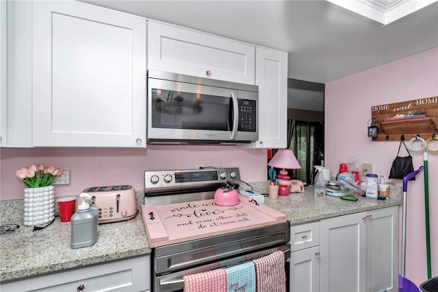 487 Midway Dr Unit B, Ocala, FL 34472 - kitchen featuring appliances with stainless steel finishes, white cabinets, and light stone countertops