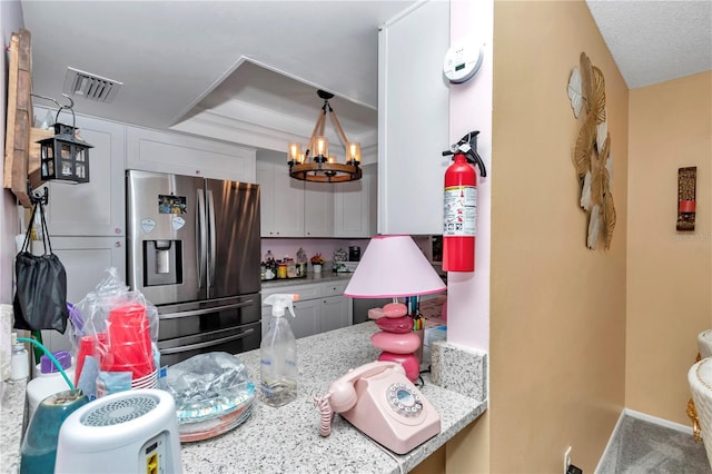 487 Midway Dr Unit B, Ocala, FL 34472 - kitchen with stainless steel fridge, a chandelier, light stone countertops, decorative light fixtures, and a tray ceiling