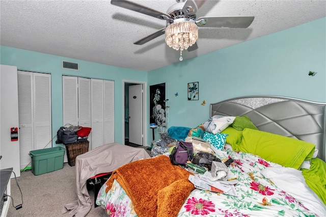487 Midway Dr Unit B, Ocala, FL 34472 - carpeted bedroom featuring two closets, a textured ceiling, and ceiling fan