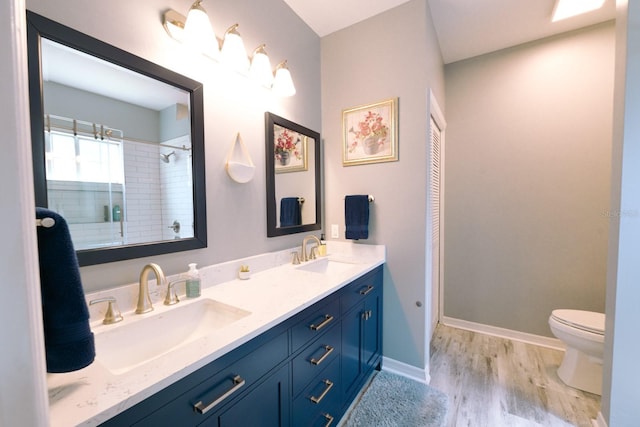 3735 NW 64th Pl, Gainesville, FL 32653 - bathroom featuring double vanity, wood finished floors, and a tile shower
