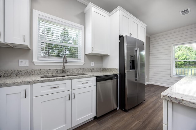 16011 S County Road 325, Hawthorne, FL 32640 - kitchen featuring appliances with stainless steel finishes, dark wood-style floors, white cabinets, light stone countertops, and wooden walls
