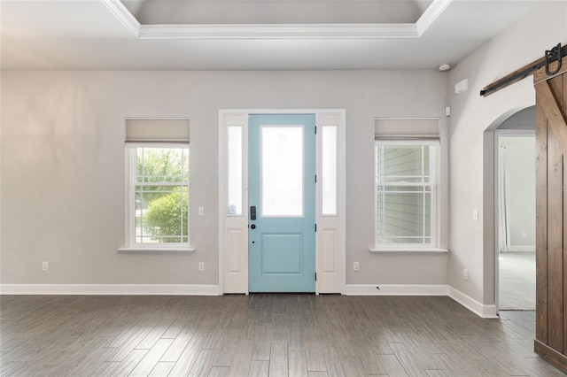 2556 SW 118th Ter, Gainesville, FL 32608 - entryway featuring a barn door, dark wood-style flooring, arched walkways, crown molding, and a raised ceiling