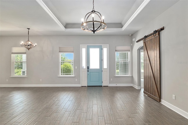 2556 SW 118th Ter, Gainesville, FL 32608 - foyer entrance featuring a chandelier, a barn door, plenty of natural light, a tray ceiling, and ornamental molding