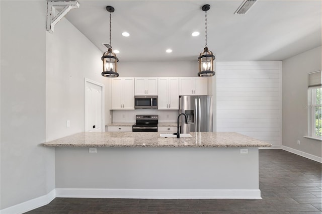 2556 SW 118th Ter, Gainesville, FL 32608 - kitchen featuring appliances with stainless steel finishes, white cabinets, light stone countertops, dark wood-type flooring, and recessed lighting