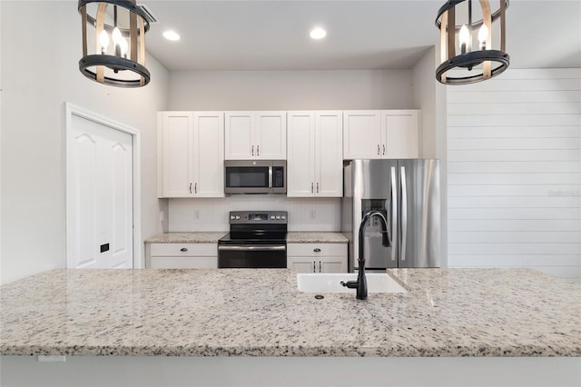 2556 SW 118th Ter, Gainesville, FL 32608 - kitchen featuring appliances with stainless steel finishes, light stone counters, backsplash, white cabinets, and a chandelier