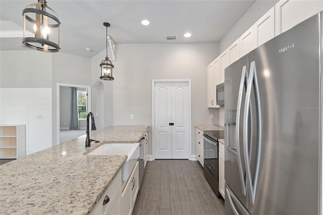 2556 SW 118th Ter, Gainesville, FL 32608 - kitchen with stainless steel appliances, white cabinetry, light stone counters, dark wood finished floors, and recessed lighting