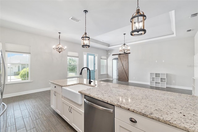 2556 SW 118th Ter, Gainesville, FL 32608 - kitchen featuring dishwasher, a tray ceiling, white cabinets, light stone countertops, and decorative light fixtures