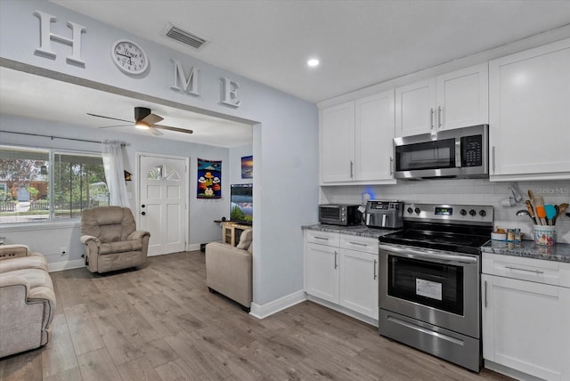 4444 5th Ave S, Saint Petersburg, FL 33711 - kitchen featuring appliances with stainless steel finishes, open floor plan, light wood-style flooring, backsplash, and recessed lighting