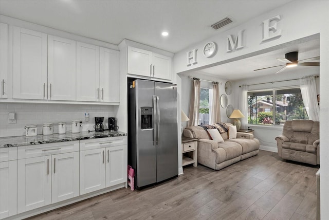 4444 5th Ave S, Saint Petersburg, FL 33711 - kitchen with stainless steel fridge with ice dispenser, open floor plan, light stone countertops, white cabinetry, and light wood-type flooring