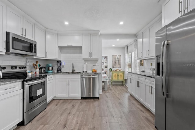 4444 5th Ave S, Saint Petersburg, FL 33711 - kitchen with appliances with stainless steel finishes, light stone counters, white cabinets, and recessed lighting