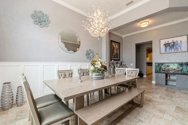 6813 SW 83rd Ter, Lake Butler, FL 32054 - dining space featuring crown molding, a chandelier, light stone finish flooring, a decorative wall, and a wainscoted wall