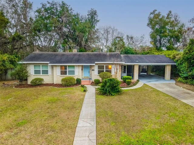 1318 NW 7th Rd, Gainesville, FL 32603 - single story home with a carport, driveway, a front yard, roof with shingles, and brick siding