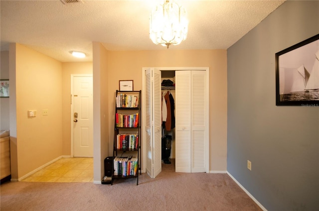 3705 SW 27th St Unit 223, Gainesville, FL 32608 - carpeted bedroom featuring a closet, a chandelier, and a textured ceiling