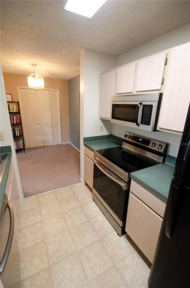 3705 SW 27th St Unit 223, Gainesville, FL 32608 - kitchen featuring stainless steel appliances, dark countertops, light carpet, a textured ceiling, and a chandelier